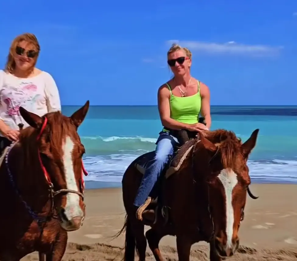 Therapeutic horse riding along ocean surf line